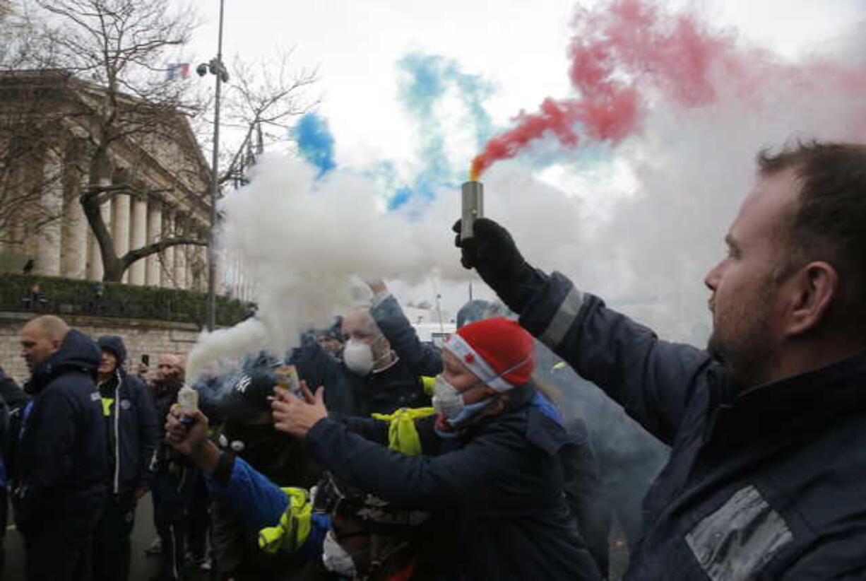 Ambulance workers hold flares outside the National Assembly in Paris, Monday, Dec. 3, 2018. Ambulance workers took to the streets and gathered close to the National Assembly in downtown Paris to complain about changes to working conditions as French Prime Minister Edouard Philippe is holding crisis talks with representatives of major political parties in the wake of violent anti-government protests that have rocked Paris.