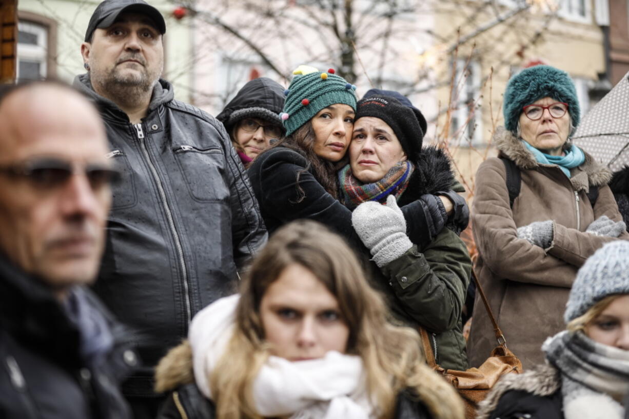 Residents react Sunday during a gathering held in a central square of the eastern French city of Strasbourg to pay homage to the victims of a gunman who killed four people and wounded a dozen more.