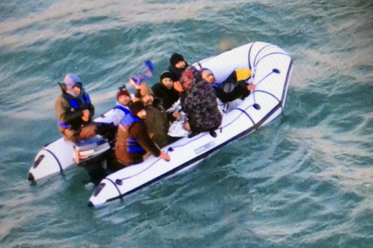 Migrants headed toward Britain aboard a rubber boat are intercepted Tuesday by the French navy off the port of Calais, France. Eight people were rescued after their engine failed.