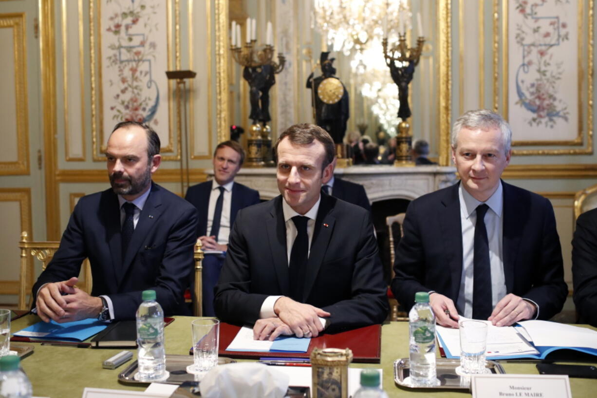 France’s President Emmanuel Macron, center, France’s Prime Minister Edouard Philippe, left, and France’s Finance Minister Bruno Le Maire, right, attend a meeting with the representatives of the banking sector at the Elysee Palace, in Paris, Tuesday, Dec.11, 2018. Macron met with representatives of the banking sector to discuss responses to bring to the Yellow Vest protesters’ claims. The meeting comes one day after he speed up tax relief and to boost the purchasing power of struggling workers and retirees in a national television address.