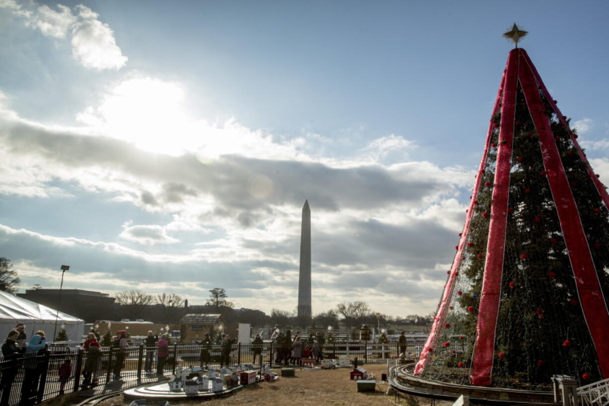 Visitors to the National Christmas Tree on the Ellipse look at holiday decorations as National Park Service employees briefly open the venue before quickly having to close again due to electrical problems, Monday, Dec. 24, 2018, in Washington. Repairs were delayed because of a partial government shutdown. Both sides in the long-running fight over funding President Donald Trump’s U.S.-Mexico border wall appear to have moved toward each other, but a shutdown of one-fourth of the federal government entered Christmas without a clear resolution in sight.