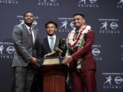 Heisman Trophy finalists, from left, Dwayne Haskins, from Ohio State; Kyler Murray, from Oklahoma; and Tua Tagovailoa, from Alabama, pose with the tophy during a media event Saturday, Dec. 8, 2018, in New York.