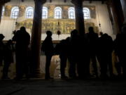 Visitors stand bellow a renovated part of a fresco inside the Church of the Nativity, built atop the site where Christians believe Jesus Christ was born, in the West Bank City of Bethlehem. City officials are optimistic that the renovated church will help add to a recent tourism boom and give a boost to the shrinking local Christian population.