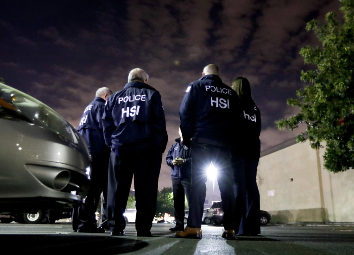 FILE - In this Jan. 10, 2018, file photo, U.S. Immigration and Customs Enforcement agents gather before serving an employment audit notice at a 7-Eleven convenience store, in Los Angeles. U.S. Immigration and Customs Enforcement is the face of President Donald Trump’s hard-line immigration policy. But agency officials say their mandate is misunderstood. Government data shows ICE is mostly targeting criminals, but also that the agency has greatly ramped up overall arrests and increased the number of people arrested solely on immigration violations. And the most frequent criminal conviction was for drunken driving.