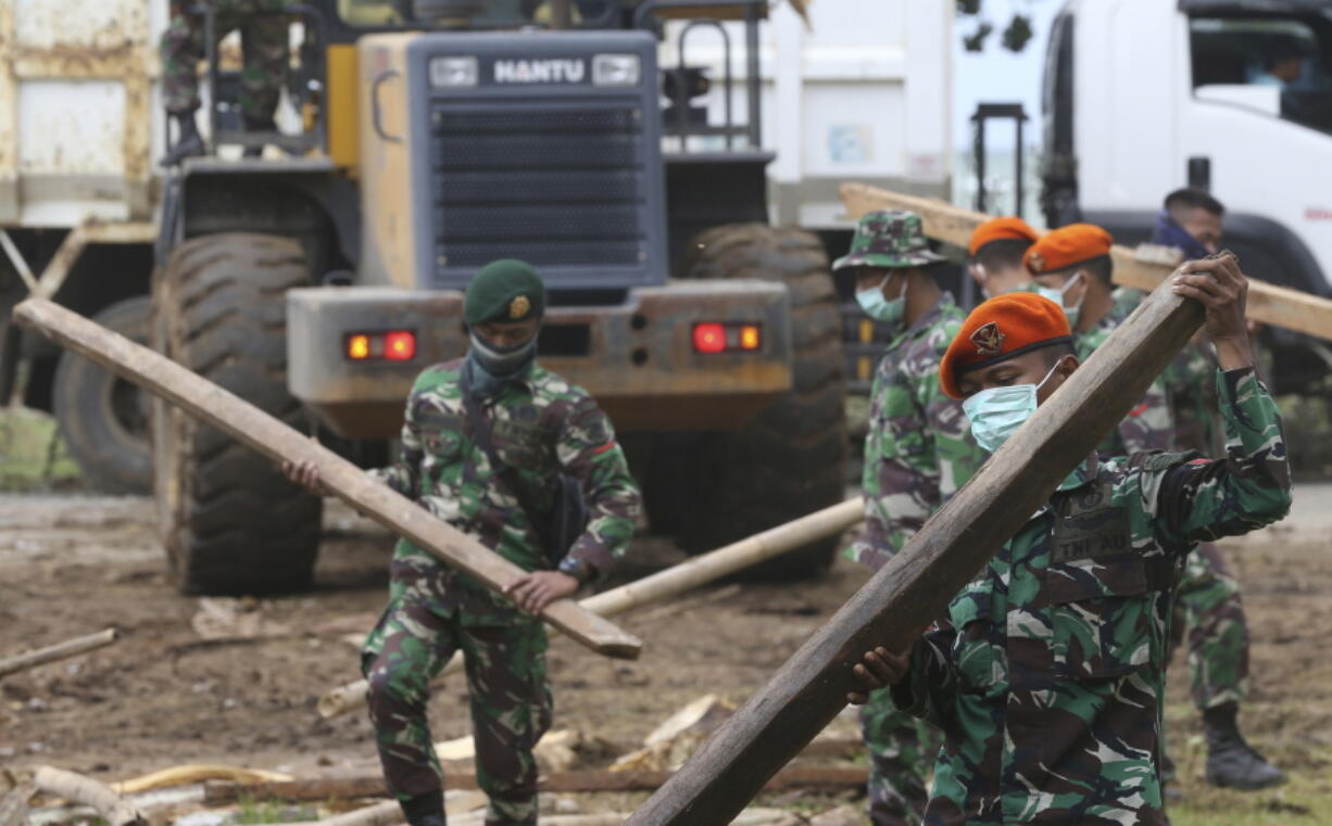 Soldiers remove debris from a damaged house in the tsunami-hit village of Carita, Indonesia, on Friday. Indonesia has widened the no-go zone around an island volcano that triggered a tsunami on the weekend, killing hundreds of people in Sumatra and Java.