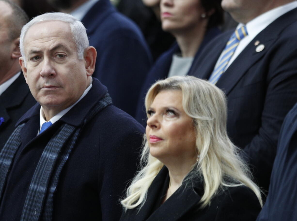 FILE - In this Nov. 11, 2018, file photo, Israeli Prime Minister Benjamin Netanyahu and his wife Sara attend ceremonies at the Arc de Triomphe in Paris. Police say Sunday, Dec. 2, 2018, they have established an evidentiary foundation to charge Netanyahu and his wife Sara with accepting bribes, fraud and breach of trust.