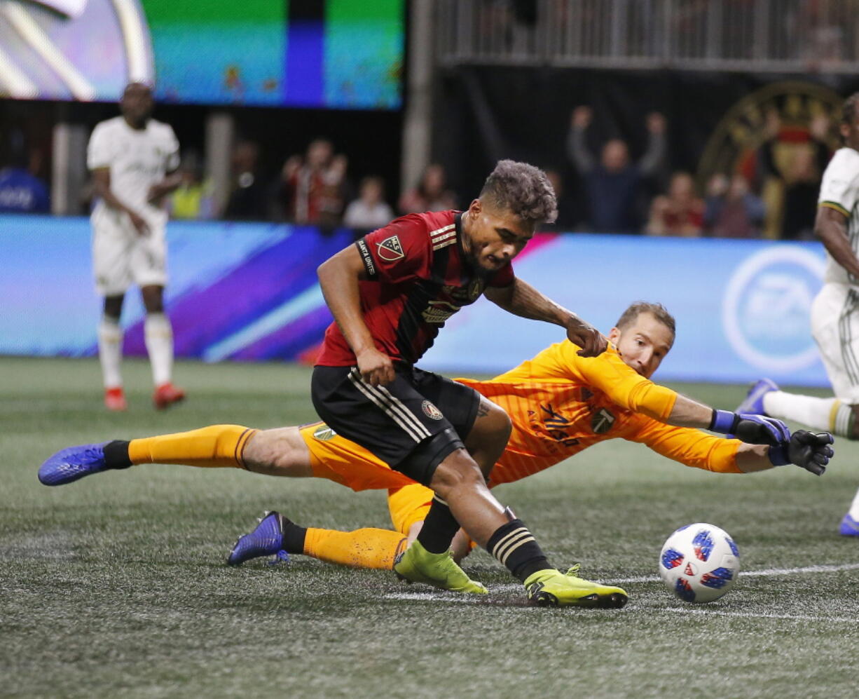 Atlanta United forward Josef Martinez (7) beats Portland Timbers goalkeeper Jeff Attinella (1) to score a goal during the first half of the MLS Cup championship soccer game, Saturday, Dec. 8, 2018, in Atlanta.