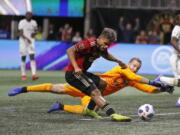 Atlanta United forward Josef Martinez (7) beats Portland Timbers goalkeeper Jeff Attinella (1) to score a goal during the first half of the MLS Cup championship soccer game, Saturday, Dec. 8, 2018, in Atlanta.