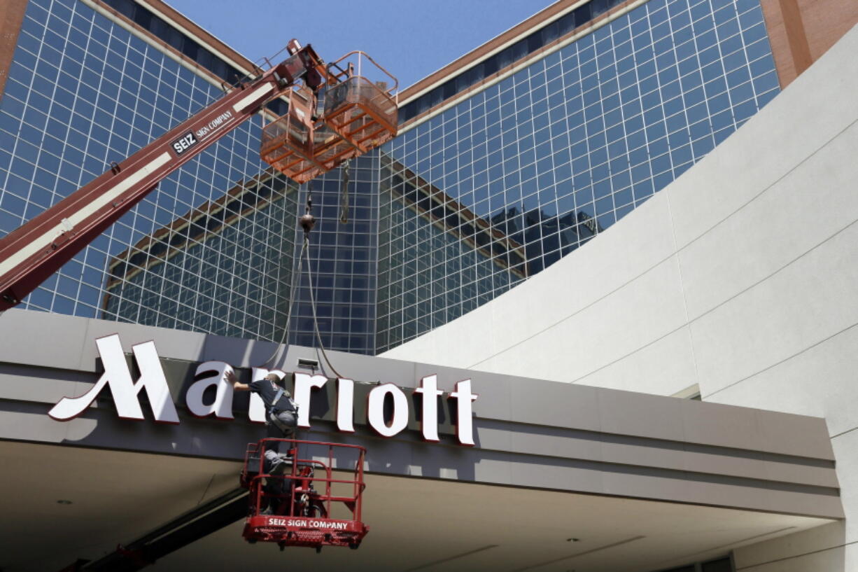 In this Tuesday, April 30, 2013, file photo, a man works on a new Marriott sign in front of the former Peabody Hotel in Little Rock, Ark. Marriott says the information of up to 500 million guests at its Starwood hotels has been compromised. It said Friday, Nov. 30, 2018, that there was a breach of its database in September, but also found out through an investigation that there has been unauthorized access to the Starwood network since 2014.