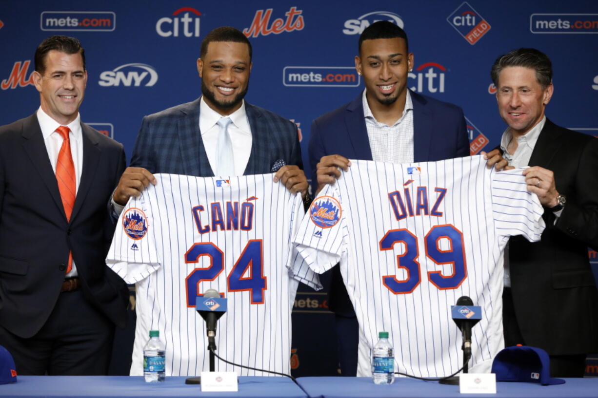 New York Mets’ Robinson Cano, second left, and Edwin Díaz, third left, pose with their new jerseys as they are introduced at a news conference at CitiField, in New York, Tuesday, Dec. 4, 2018. The Mets acquired eight-time All-Star second baseman Robinson Cano and major league saves leader Edwin Diaz from the Seattle Mariners in a seven-player trade Monday. They are joined by New York Mets General Manger Brodie Van Wagenen, left, and team COO Jeff Wilpon.