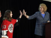 Seattle Mayor Jenny Durkan, right, high-five’s Washington Wild hockey team wing Jaina Goscinski, 11, as Tod Leiweke, CEO of NHL Seattle, looks on during a news conference Oct. 2 in Seattle. The NHL Board of Governors is meeting Tuesday in Sea Island, Ga., to give final approval to Seattle’s bid to add the league’s 32nd team.