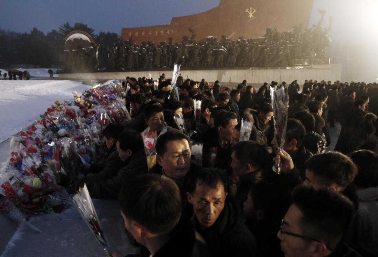 North Koreans lay flowers at the base of bronze statues of their late leaders Kim Il Sung and Kim Jong Il at Mansu Hill Grand Monument on Sunday in Pyongyang, North Korea.