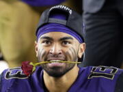 Washington linebacker Brandon Wellington holds a rose in his mouth as he celebrates with teammates after Washington defeated Utah 10-3 in the Pac-12 Conference championship NCAA college football game in Santa Clara, Calif., Friday, Nov. 30, 2018.