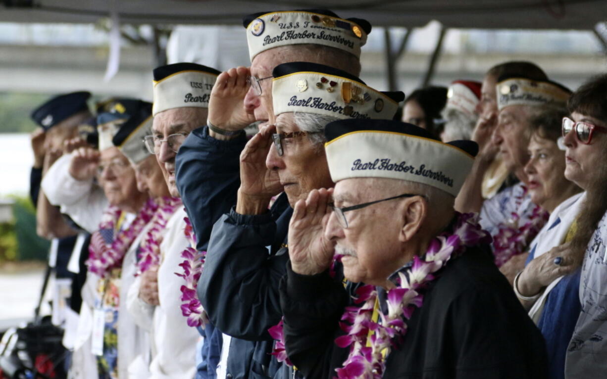 Pearl Harbor survivors salute during the National Anthem at a ceremony Friday in Pearl Harbor, Hawaii, marking the 77th anniversary of the Japanese attack.