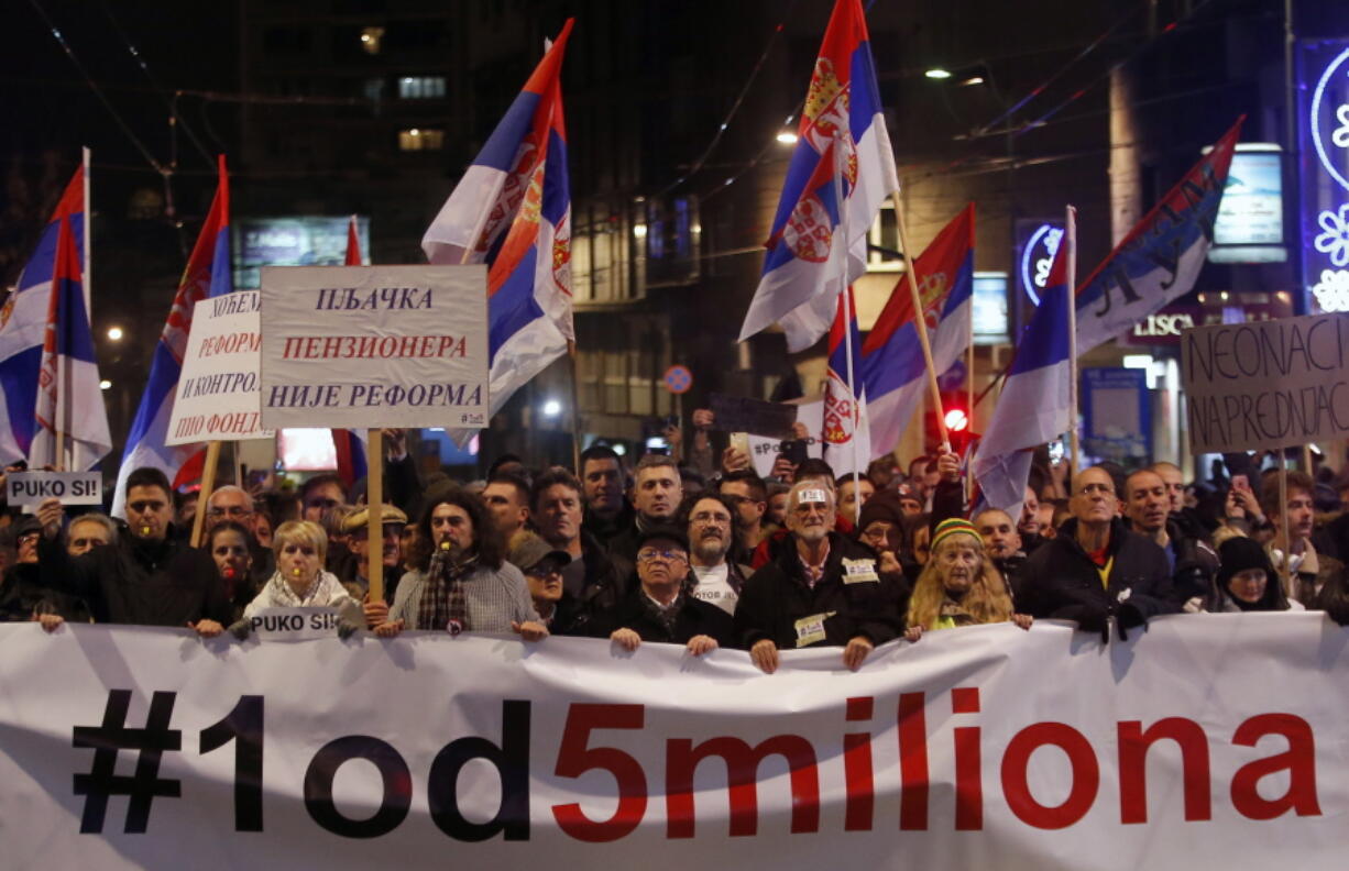 People hold a banner that reads: ‘’#1 out of 5 million’’ during a protest against populist President Aleksandar Vucic on Saturday in Belgrade, Serbia. Similar protests have been held for the past three weekends.