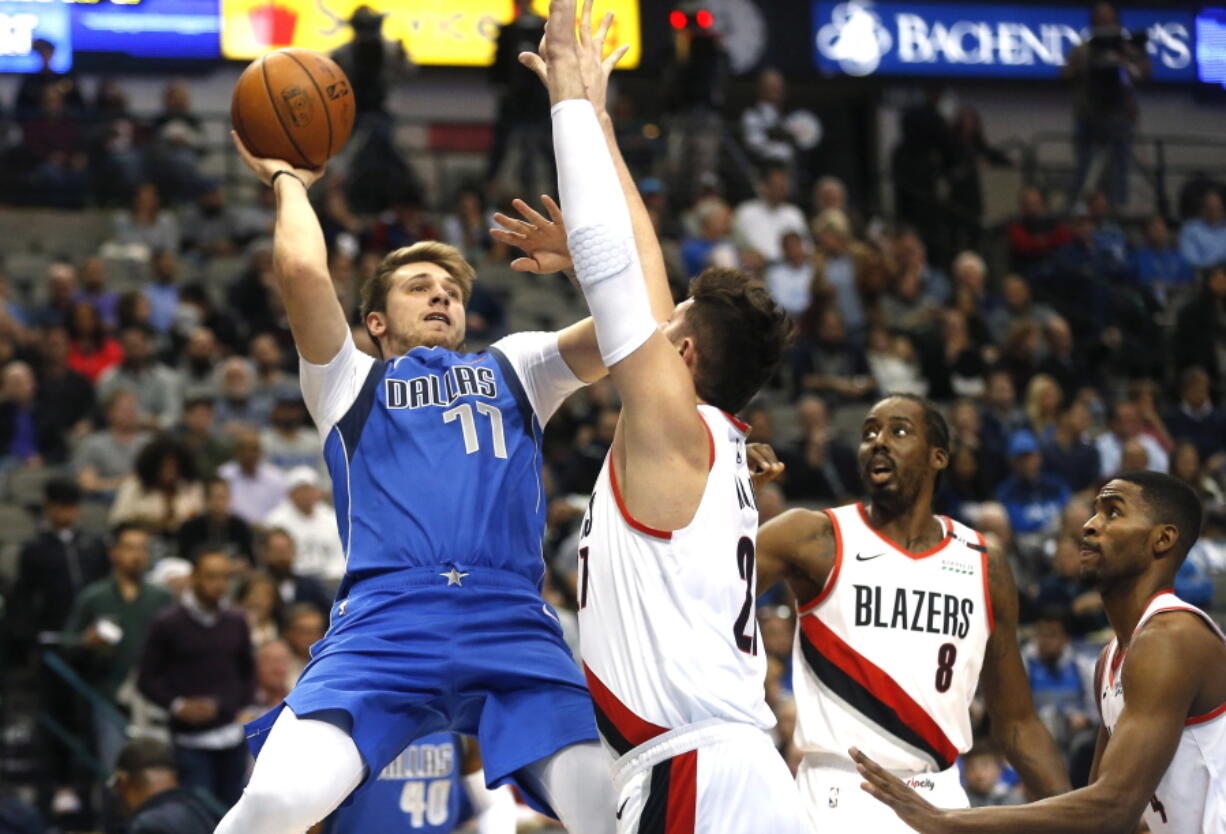 Dallas Mavericks forward Luka Doncic (77) attempts a shot over Portland Trail Blazers center Jusuf Nurkic (27) as Portland Trail Blazers Al-Farouq Aminu (8) and Maurice Harkless (4) look on during the first half of an NBA basketball game, Tuesday, Dec. 4, 2018, in Dallas.