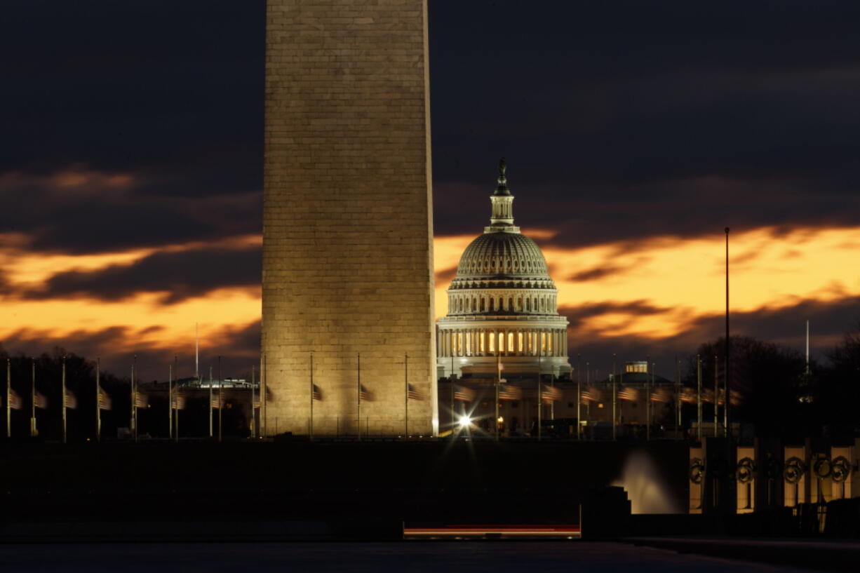 The U.S. Capitol dome is seen past the base of the Washington Monument just before sunrise in Washington, Saturday, Dec. 22, 2018. Hundreds of thousands of federal workers faced a partial government shutdown early Saturday after Democrats refused to meet President Donald Trump’s demands for $5 billion to start erecting a border wall with Mexico.