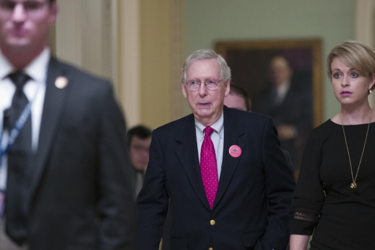 Senate Majority Leader Mitch McConnell of Ky., center, walks back to his office as they work to pass a bill that would pay for President Donald Trump’s border wall and avert a partial government shutdown, on Capitol Hill, Friday, Dec. 21, 2018 in Washington.