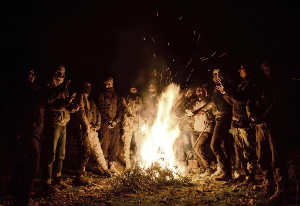 Turkey-backed Free Syrian Army soldiers wait late Friday near the northern Syrian city of Manbij. Syria’s military announced Friday that it entered the flashpoint Kurdish-held town of Manbij, where Turkey has threatened an offensive and raised the national flag.