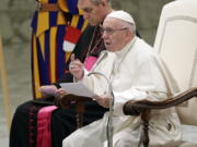 Pope Francis, flanked by Vatican Prefect of the Pontifical Household, Archbishop Georg Ganswein, delivers his message during a weekly general audience, in the Pope Paul VI hall, at the Vatican, Wednesday, Dec. 5, 2018.