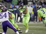 Seattle Seahawks’ Rashaad Penny, center, carries against the Minnesota Vikings in the first half of an NFL football game, Monday, Dec. 10, 2018, in Seattle.