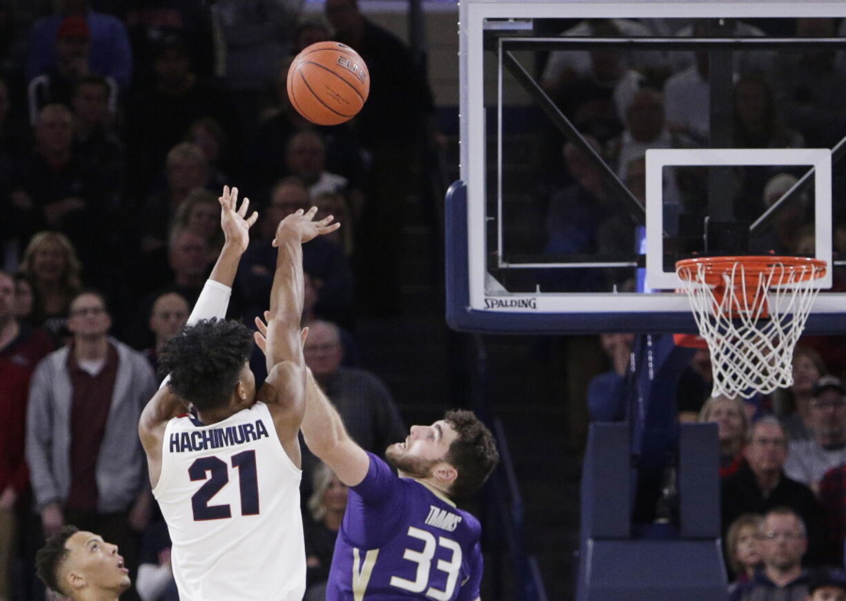 Gonzaga forward Rui Hachimura (21) shoots the go-ahead basket while defended by Washington’s Sam Timmins (33).