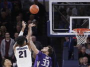 Gonzaga forward Rui Hachimura (21) shoots the go-ahead basket while defended by Washington’s Sam Timmins (33).