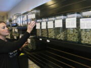 FILE - In this Oct. 26, 2018, file photo, Diana Calvert, River City Retail Marijuana Dispensary manager in Merlin, Ore., stocks the shelves with product. Efforts to regulate the marijuana industry is one of Oregon’s top 2018 stories.