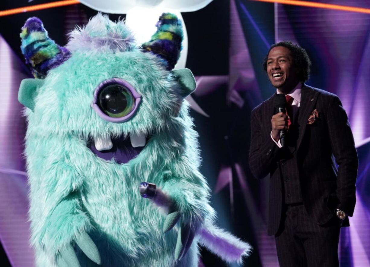 The monster and host Nick Cannon in “The Masked Singer.” Michael Becker/Fox