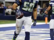 Seattle Seahawks outside linebacker K.J. Wright (50) runs with the ball after an interception against the Dallas Cowboys during the second half of the NFC wild-card NFL football game in Arlington, Texas, Saturday, Jan. 5, 2019.