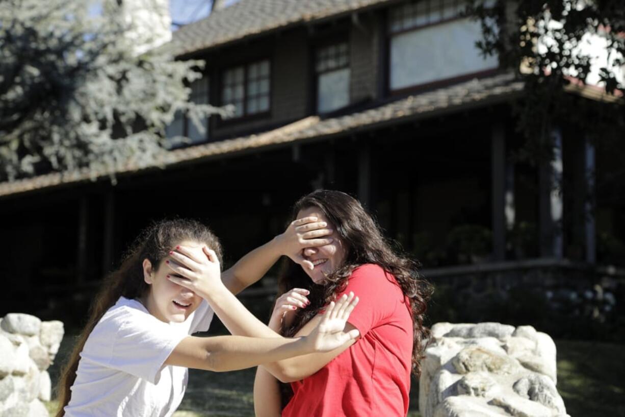 Abby Olague, 15, left, and her sister Bella Olague, 14, of Chino, Calif., improvise their “Bird Box” pose Jan. 4 at the “Bird Box” house in Monrovia, Calif. Myung J.