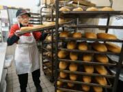 Giant bakery associate Wynnifred Franklin, 94, pulls freshly baked rolls from the bakery racks.