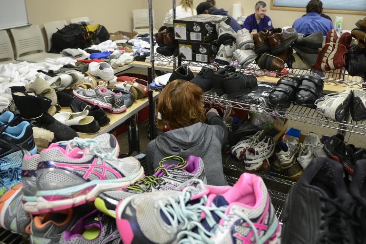 Mary Miller of Fit Right NW searches through donated shoes at Project Homeless Connect at St. Joseph Catholic Church.