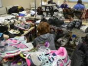 Mary Miller of Fit Right NW searches through donated shoes at Project Homeless Connect at St. Joseph Catholic Church.