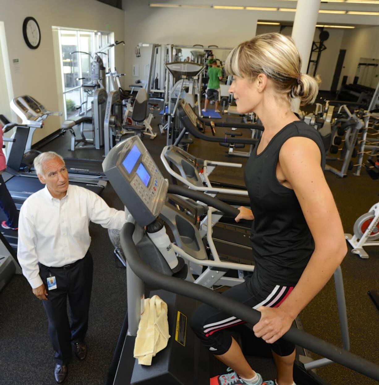 Nautilus CEO Bruce Cazenave, left, speaks with Amy Scharnhorst as she exercises on a StairMaster during her break at Nautilus’ headquarters.