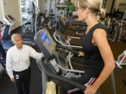 Nautilus CEO Bruce Cazenave, left, speaks with Amy Scharnhorst as she exercises on a StairMaster during her break at Nautilus’ headquarters.