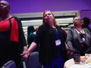 Velda Asbury, left, Irma Cancel and Chandra Best hold hands as the D.C. Labor Chorus performs at a prayer breakfast during the AFL-CIO Martin Luther King Jr. Civil and Human Rights Conference at the Washington Hilton on Sunday, Jan. 20, 2019. MUST CREDIT: Washington Post photo by Matt McClain.