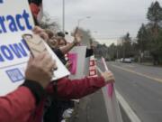 Members of the Vancouver Association of Educational Support Professionals wave signs outside Vancouver Public Schools district offices Thursday, as the union and district continued to negotiate a contract for support staff.