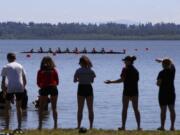 Fans watch from the shore at the U.S. Rowing Northwest Youth Championships at Vancouver Lake. Invasive Eurasian milfoil is threatening to choke off the race course, threatening future regattas.