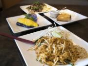 The pad thai with chicken, clockwise from front, fresh mango and ice cream dessert, beef salad and crispy vegetarian rolls are available at Kindee Thai.