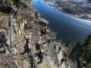 Hikers climb above the Columbia River Gorge during Washington State Parks’ First Day Hike at Beacon Rock State Park on Tuesday morning. The 848-foot rock features 52 switchbacks over less than a mile.