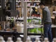 Alfredo Tezoco of Biokleen sorts through bottles of cleaners while working with colleagues at Biokleen’s Vancouver factory.