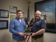 Jay Lorentz, operations manager at ArgenTech Solutions, left, and Marcel Piet, the company’s president of defense services, hold the 2018 Secretary of Defense Employer Support Freedom Award on Monday at ArgenTech Solutions in Vancouver.