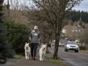 Camas’ Prune Hill has the highest life expectancy of anywhere in Clark County. Camas resident Austin Stevens walks twin dogs, Bailey, left, and Astro, both 1, along the sidewalk on Northwest Dahlia Drive on Tuesday afternoon. He said both dogs need to be walked frequently. “It’s a very safe environment to do that,” he said.