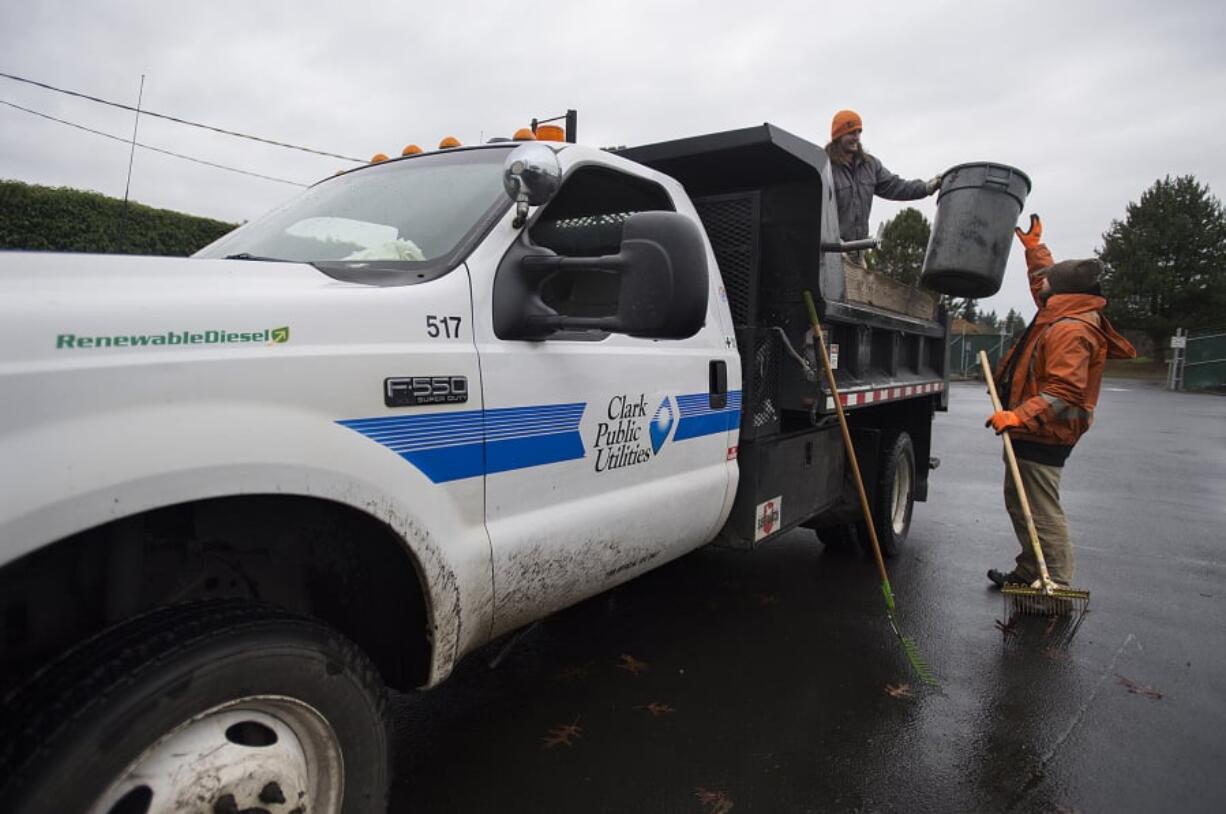 Clark Public Utilities grounds maintenance workers Winston Matz, left, and Riley Luke use their truck, which uses renewable diesel, to help clear leaves at the utility’s operations center in Orchards on Wednesday afternoon. The utility has been gradually transitioning its fleet to more fuel-efficient, lower-emission and easier-to-maintain vehicles.