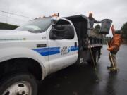 Clark Public Utilities grounds maintenance workers Winston Matz, left, and Riley Luke use their truck, which uses renewable diesel, to help clear leaves at the utility’s operations center in Orchards on Wednesday afternoon. The utility has been gradually transitioning its fleet to more fuel-efficient, lower-emission and easier-to-maintain vehicles.