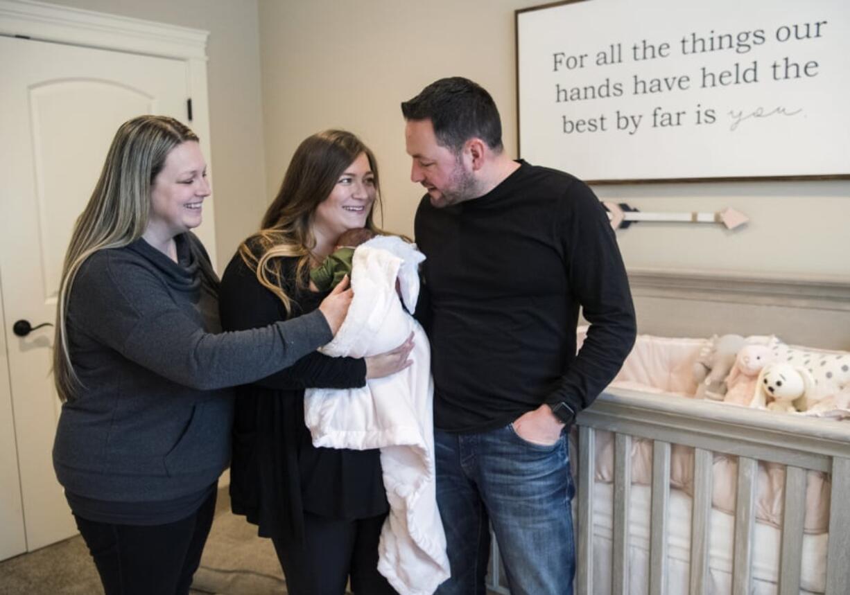 Alicia Green joins Cristina and Haris Hadziselimovic and their newborn Avyn at the Hadziselimovic’s home in Ridgefield. Green, Columbia River’s gymnastics coach, served as surrogate for her sister Cristina after the couple struggled to get pregnant for years.