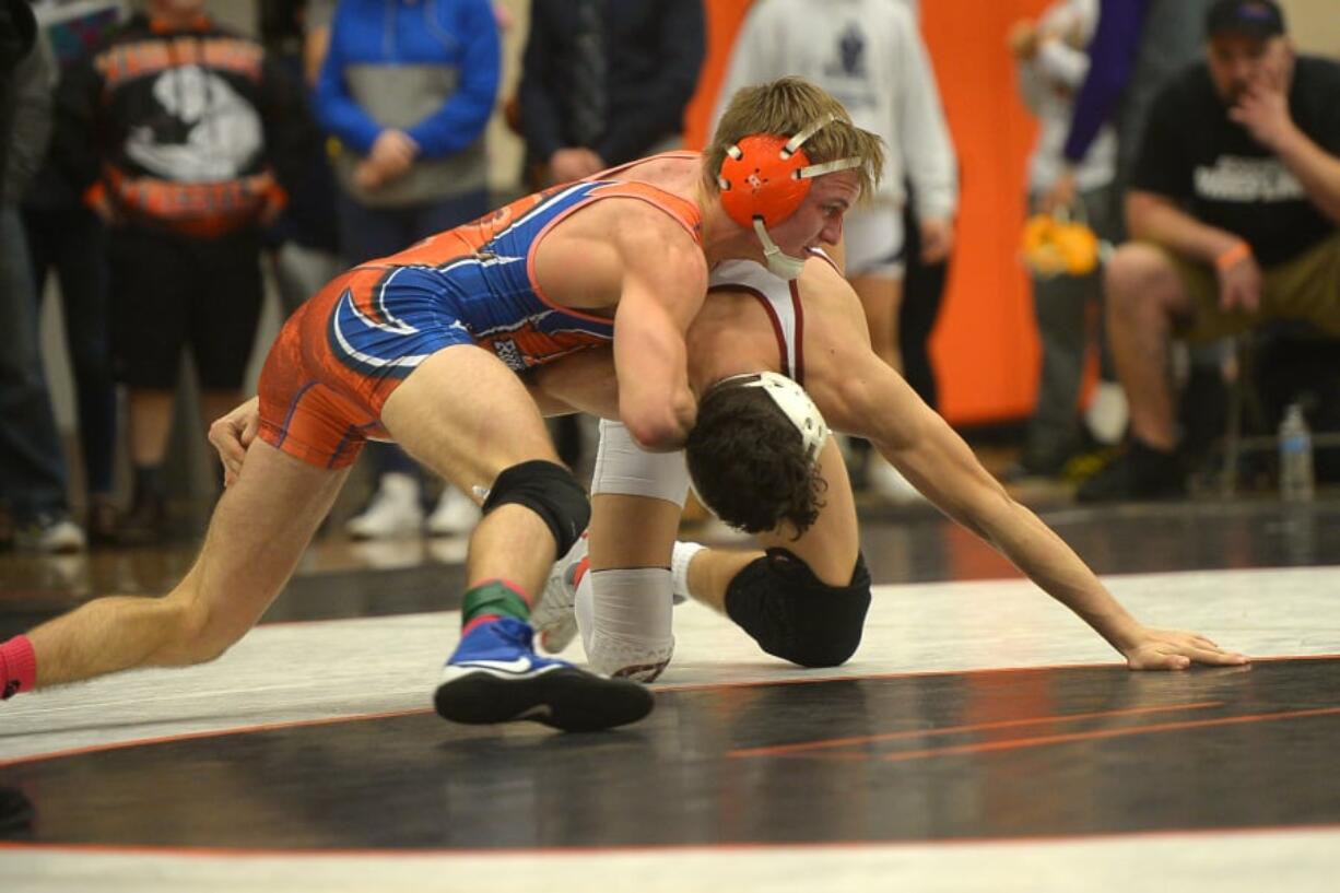 Ridgefield’s Dylan Draper, top, takes on Prairie’s Jason Wilcox in the 132-pound final Saturday at the Clark County Wrestling Championship at Battle Ground. Draper won with a late takedown, 3-1.