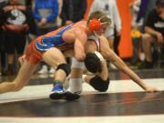 Ridgefield’s Dylan Draper, top, takes on Prairie’s Jason Wilcox in the 132-pound final Saturday at the Clark County Wrestling Championship at Battle Ground. Draper won with a late takedown, 3-1.