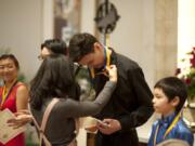 Union High School’s Aaron Greene, 17, and the other performers at the Vancouver Symphony Orchestra’s 25th annual Young Artists Competition get their medals Sunday at Trinity Lutheran Church after an afternoon of performing.